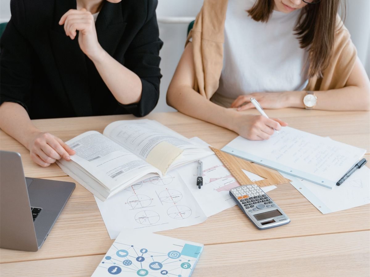 Researchers reviewing books, notes and documents at a study table